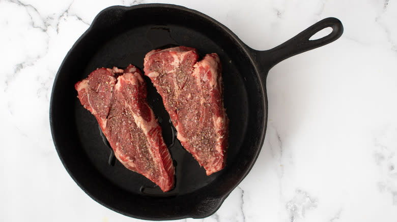 steaks cooking in skillet