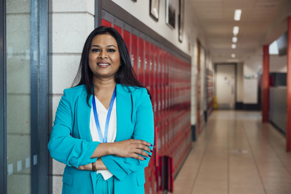 principal standing in a school hallway