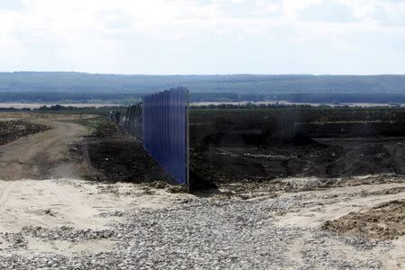 Workers install a fence at a construction site for Russia's new military base near the Russian-Ukrainian border in the village of Soloti, southeast of Belgorod, Russia, September 7, 2015. REUTERS/Anton Zverev