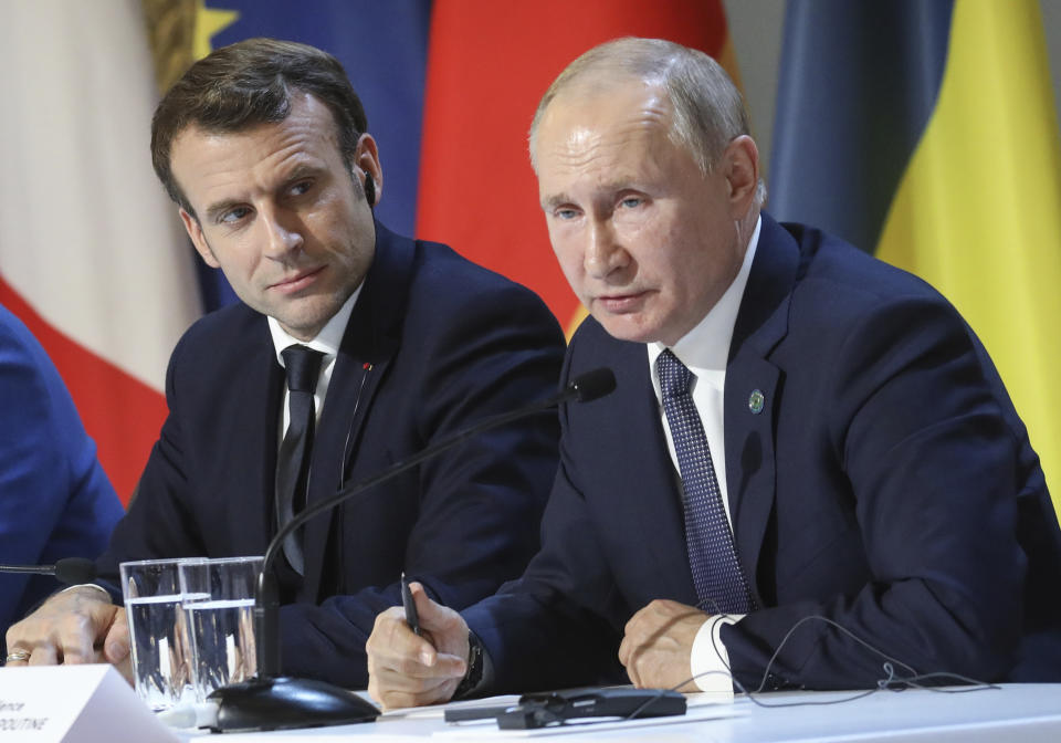 French President Emmanuel Macron and Russian President Vladimir Putin, right, attend a joint news conference with Ukraine's President Volodymyr Zelenskiy and German Chancellor Angela Merkel at the Elysee Palace in Paris, Monday Dec. 9, 2019. Russian President Vladimir Putin and Ukrainian President Volodymyr Zelenskiy met for the first time Monday at a summit in Paris to try to end five years of war between Ukrainian troops and Russian-backed separatists. (Ludovic Marin/Pool via AP)