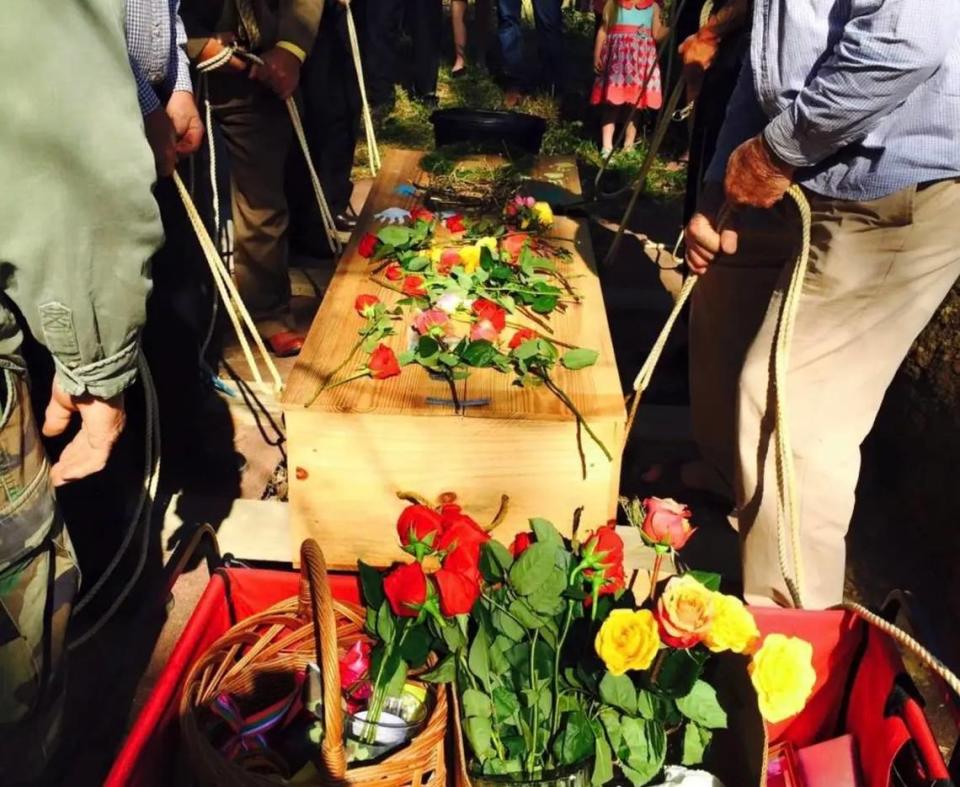 Mourners carry a simple, wooden casket through the Glendale Memorial Nature Preserve.