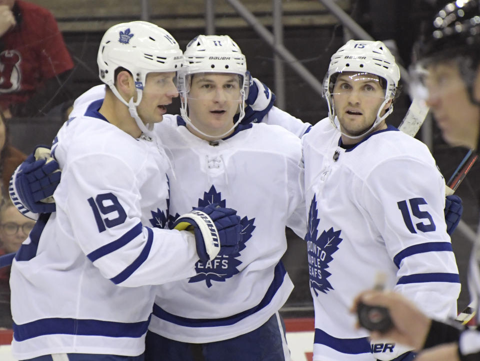 Toronto Maple Leafs left wing Zach Hyman (11) celebrates his goal with Jason Spezza (19) and Alexander Kerfoot (15) during the first period of an NHL hockey game against the New Jersey Devils, Friday, Dec. 27, 2019, in Newark, N.J. (AP Photo/Bill Kostroun)