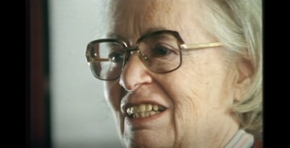 A smiling Joan Clarke surrounded by some of the men she worked with