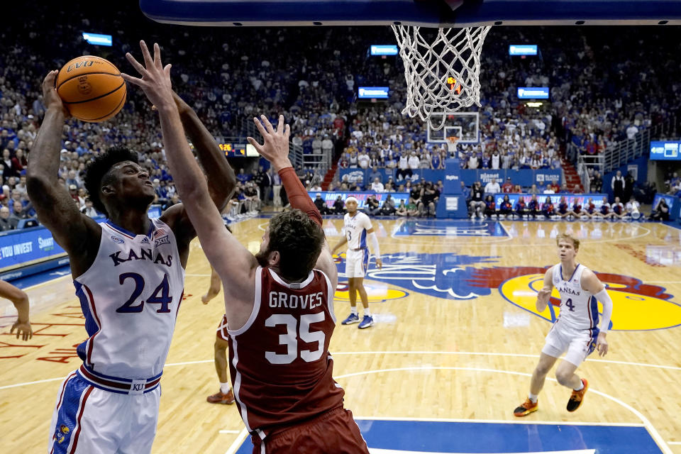 Kansas forward K.J. Adams Jr. (24) shoots over Oklahoma forward Tanner Groves (35) during the first half of an NCAA college basketball game Tuesday, Jan. 10, 2023, in Lawrence, Kan. (AP Photo/Charlie Riedel)