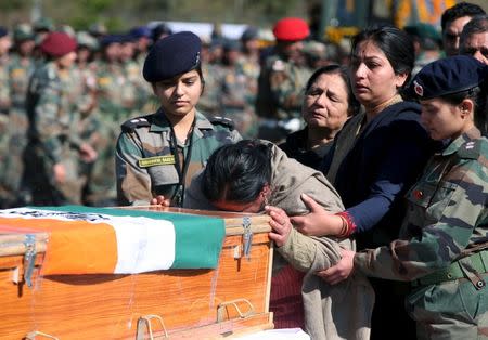The mother of Tushar Mahajan, an Indian army officer who was killed in a gunbattle, weeps as she touches the coffin of her son Tushar during his wreath laying ceremony in Udhampur, north of Jammu, February 22, 2016. REUTERS/Mukesh Gupta