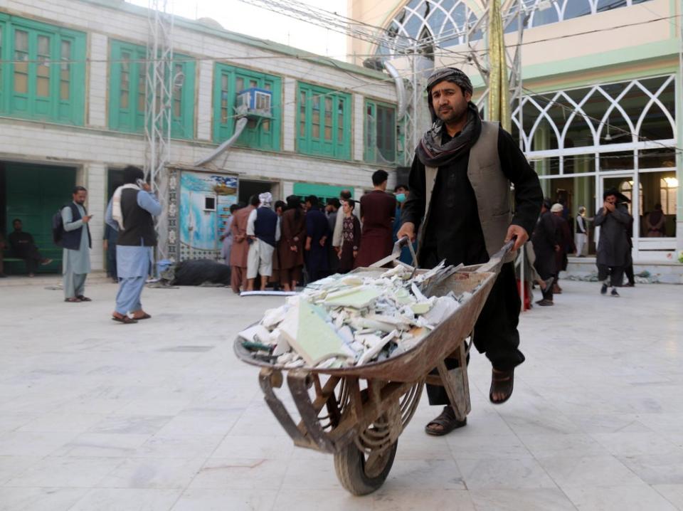 Clearing up after the attack in Kandahar (EPA)