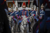 Members of the royal guard wearing face masks to prevent the spread of the coronavirus ride towards the foreign ministry in downtown Madrid, Spain, Wednesday, Sept. 30, 2020. The Spanish capital and its suburbs, the region in Europe where a second coronavirus wave is expanding by far the fastest, are edging closer to stricter mobility curbs and limits on social gatherings after days of a political row that has angered many Spaniards. (AP Photo/Bernat Armangue)