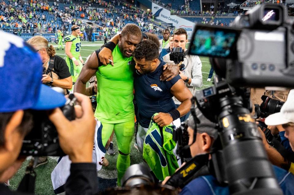 Seattle Seahawks wide receiver DK Metcalf (14) and Denver Broncos quarterback Russell Wilson (3) hug after the Seattle Seahawks defeated the Denver Broncos 17-16 at an NFL game on Monday, Sept. 12, 2022, at Lumen Field in Seattle.