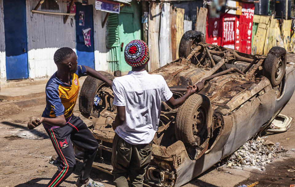 Protesters throw stones towards police officers during a rally called by the opposition leader Raila Odinga over the high cost of living in Kibera Slums, Nairobi, Monday, March 27, 2023. Police in Kenya are on high alert ahead of the second round of anti-government protests organized by the opposition that has been termed as illegal by the government. Police chief Japheth Koome insists that Monday's protests are illegal but the opposition leader Raila Odinga says Kenyans have a right to demonstrate. (AP Photo/Samson Otieno)