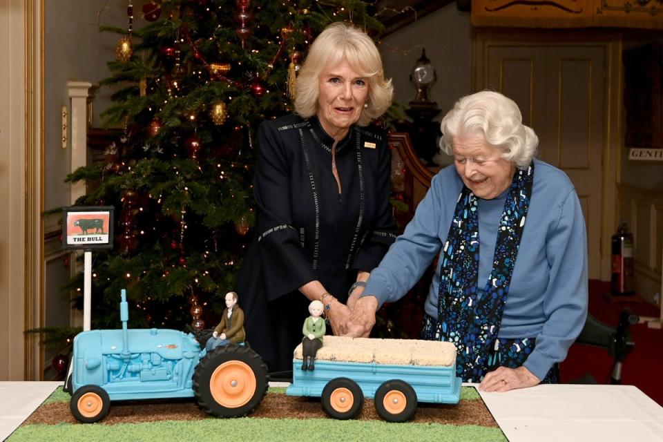 Duchess of Cornwall (left) and June Spencer cut an Archers themed cake during a reception to celebrate the 70th anniversary of the programme at Clarence House (Kate Green/PA) (PA Archive)