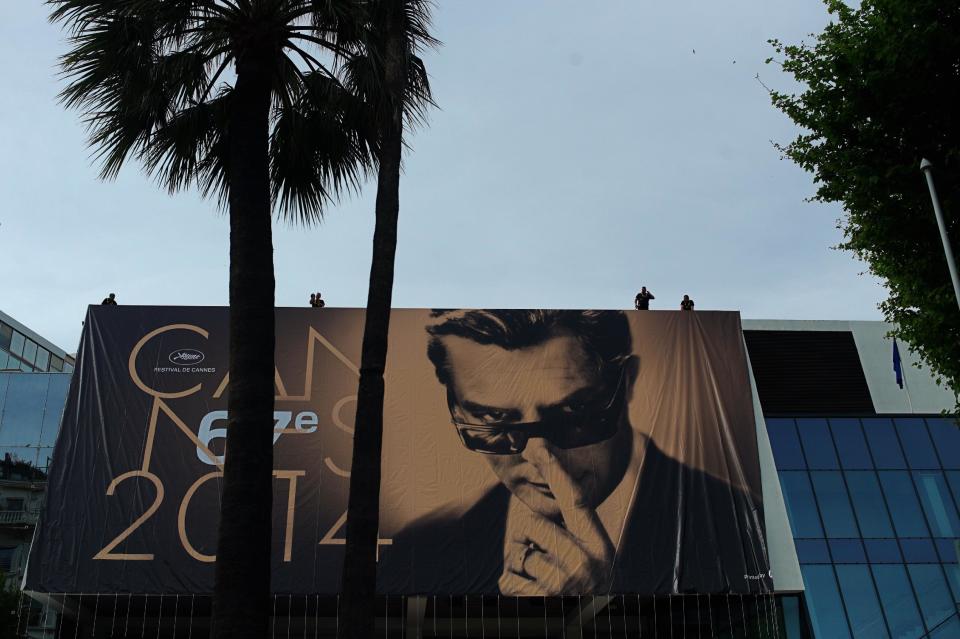 Workers place a banner depicting Marcello Mastroianni from Federico Fellini’s film 8½ on the Palais during preparations for the 67th international film festival, Cannes, southern France, Monday, May 12, 2014. The festival runs from May 14 to May 25. (AP Photo/Thibault Camus)