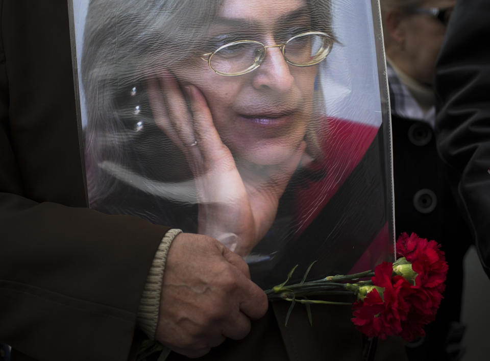 An elderly woman holds a portrait of slain journalist Anna Politkovskaya,during a rally in downtown Moscow, Sunday, Oct. 7, 2012. About 200 people rallied Thursday on the 6th anniversary of the killing of Anna Politkovskaya, calling on the authorities to find and punish the killers of journalists and human rights activists in Russia. (AP Photo/Alexander Zemlianichenko)