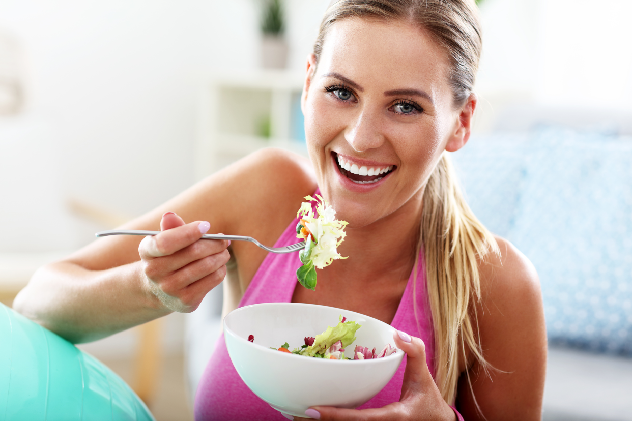 Fitness woman eating a bowl of salad