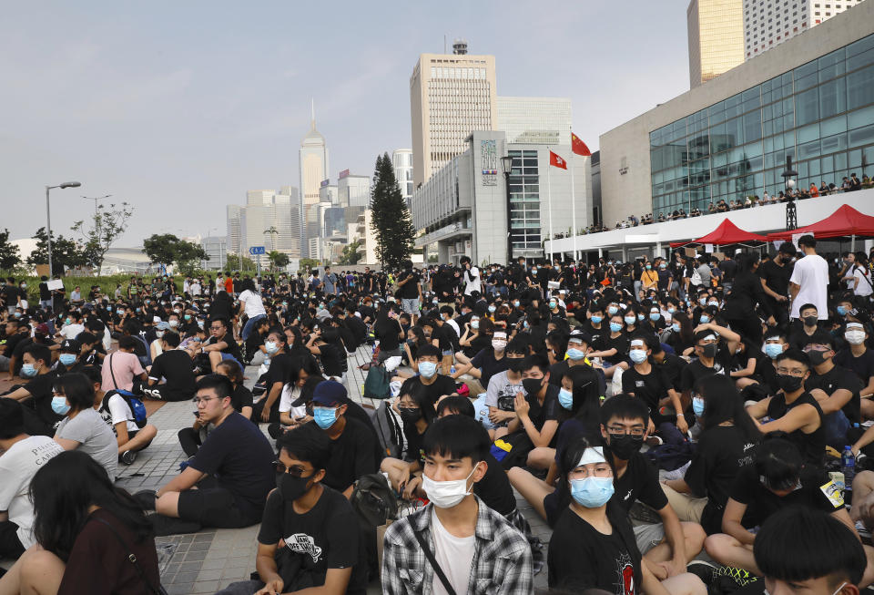 Students and others gather during a demonstration at Edinburgh Place in Hong Kong, Thursday, Aug. 22, 2019. High school students thronged a square in downtown Hong Kong Thursday to debate political reforms as residents gird for further anti-government protests. (AP Photo/Vincent Yu)