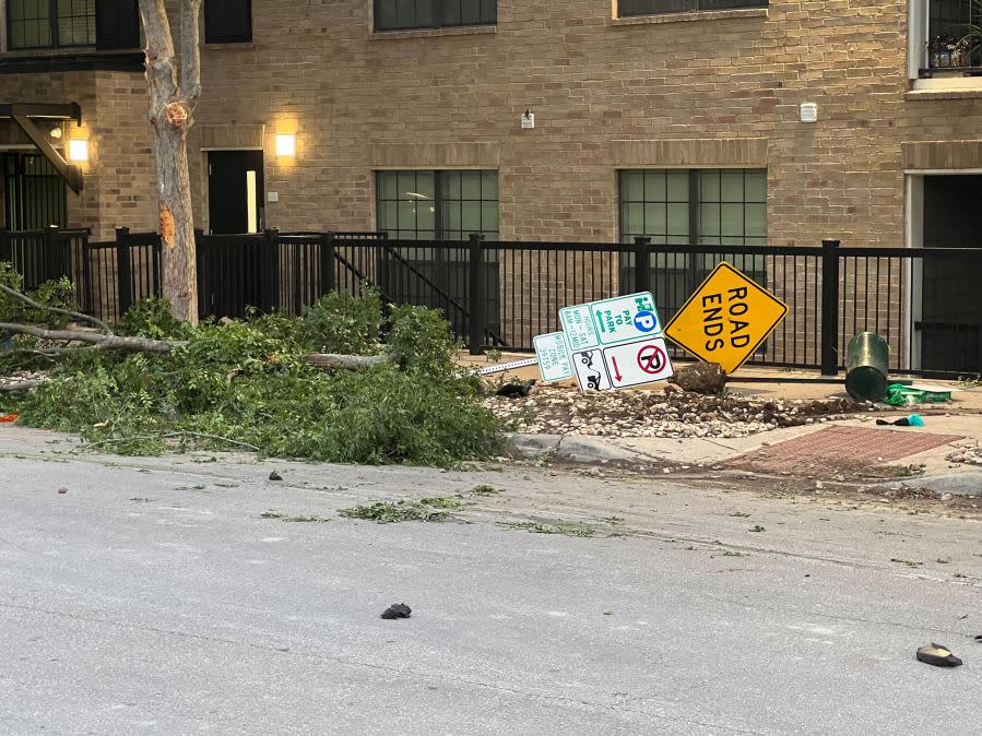 Damage to cars, street signs, etc. along East 9th Street near Embassy Drive after an 18-wheeler crashed into 10 parked vehicles overnight April 22, 2024 (KXAN Photo/Todd Bailey)