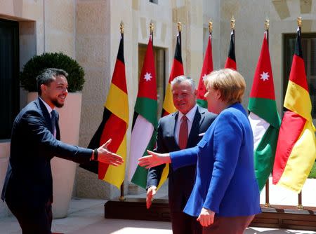 German Chancellor Angela Merkel shakes hands with Crown Prince Hussein at the Royal Palace in Amman, Jordan, June 21, 2018. REUTERS/Muhammad Hamed