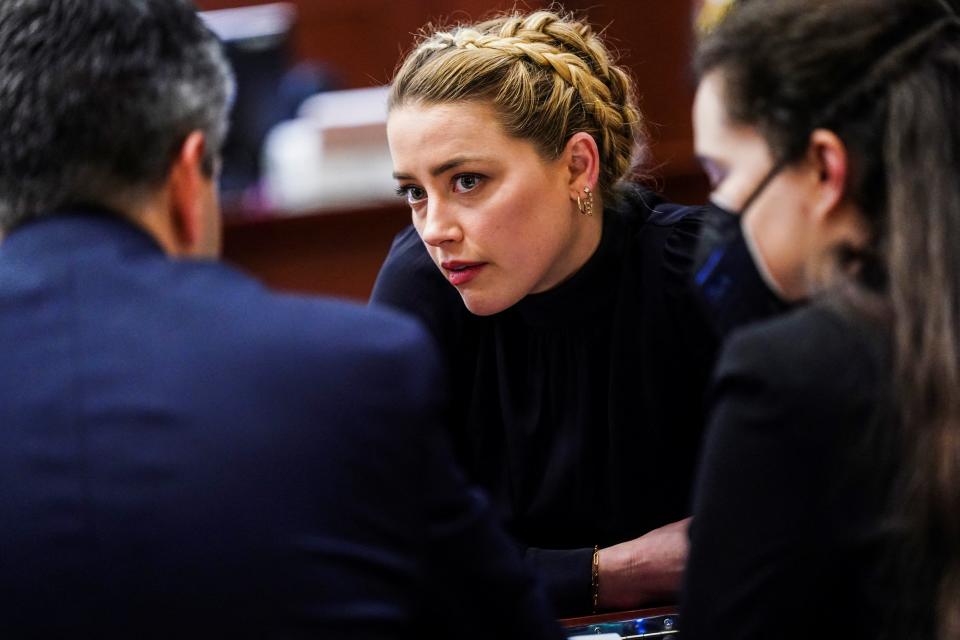 Amber Heard confers with her legal team (REUTERS)