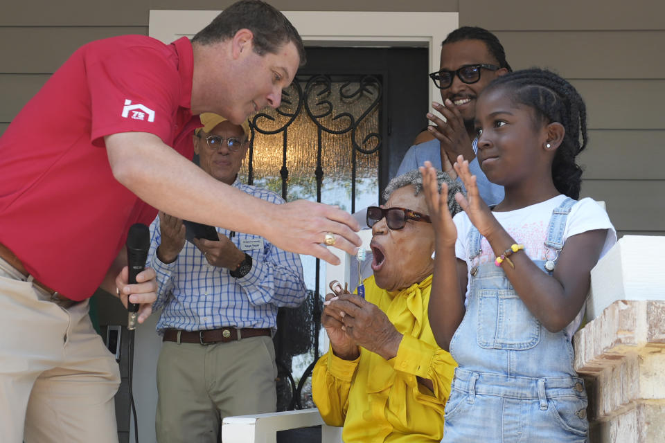 Opal Lee, center, reacts after Nelson Mitchell presented her with keys for her new home in Fort Worth, Texas, Friday, June 14, 2024. Habitat for Humanity built Lee the home on the same lot where as a child a white mob destroyed her family's home driving them away. (AP Photo/LM Otero)