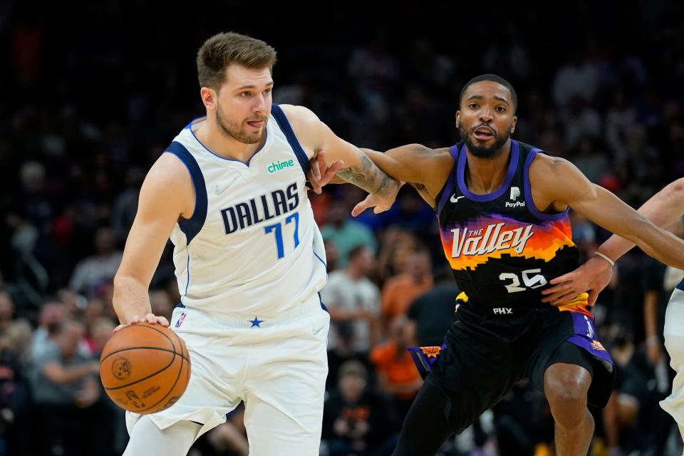 Dallas Mavericks guard Luka Doncic drives around Phoenix Suns forward Mikal Bridges during the first half of Game 1 in the second round of the NBA Western Conference playoff series Monday, May 2, 2022, in Phoenix.