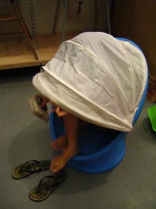 Folding chair with cover in IKEA, concealing the top half of a person