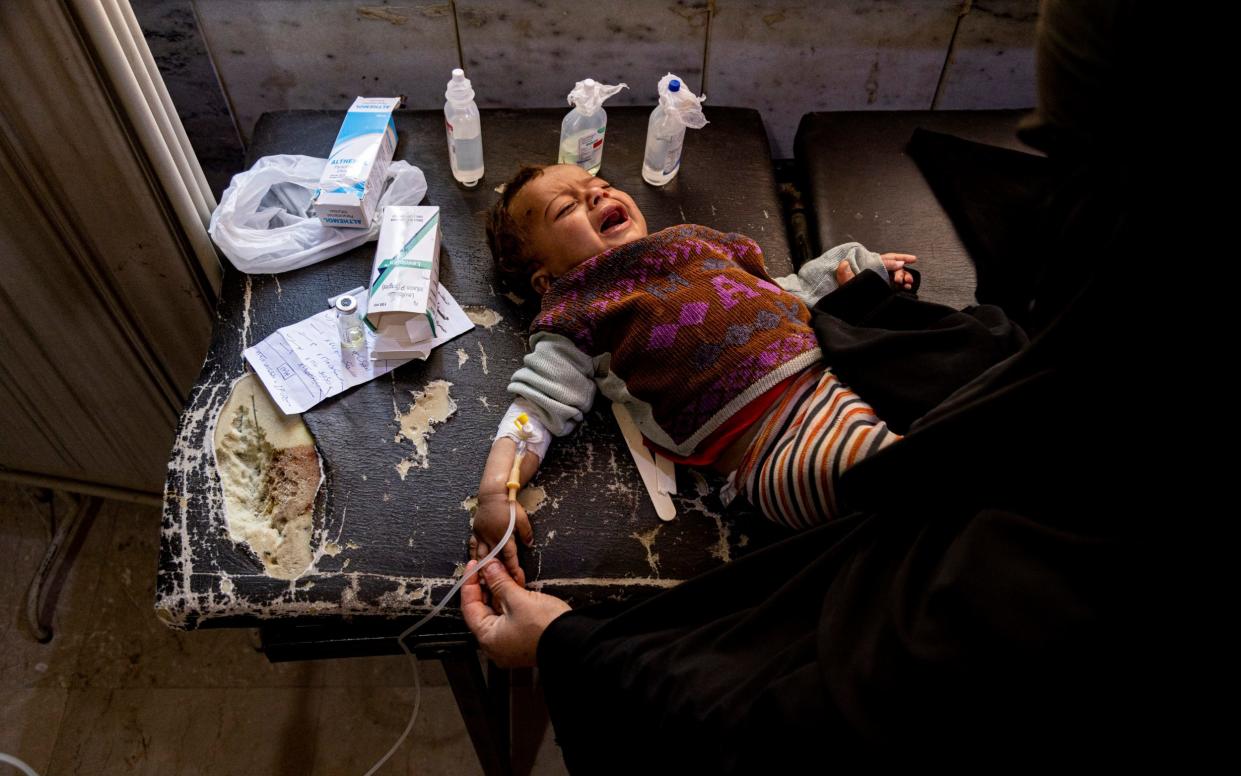 Mother holds her child diagnosed with cholera in a hospital in Deir el-Zour, Syria