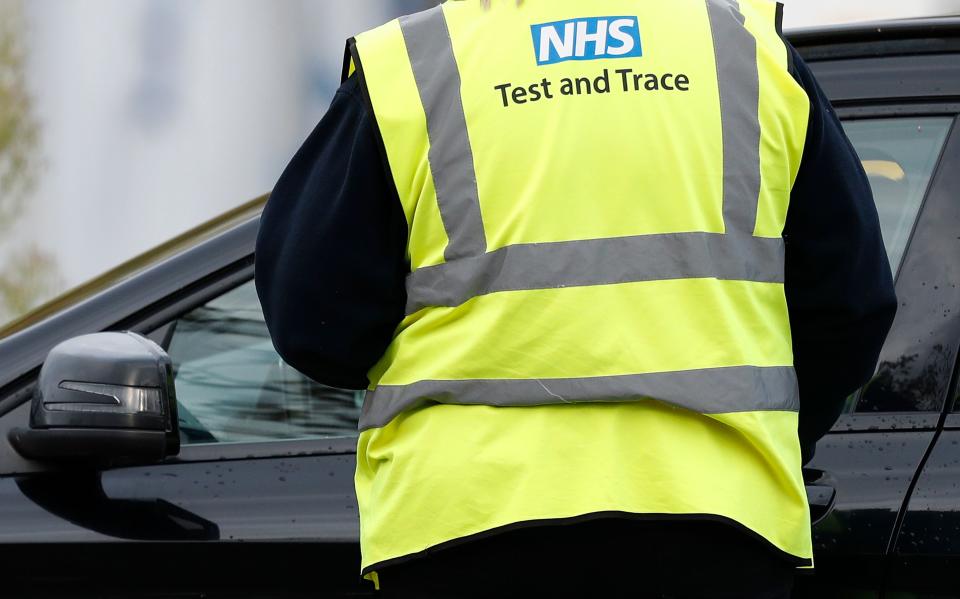 A worker wearing a high-vis jacket with an NHS Test and Trace logo on, advises drivers attending a novel coronavirus COVID-19 drive-in testing facility set up at the Chessington World of Adventures Resort, in Chessington, southwest of London, on October 20, 2020. - British Prime Minister Boris Johnson, who was criticised for acting too slowly earlier in the year, favours a strategy of localised lockdowns in England to avoid worsening the historic recession sparked by the outbreak. (Photo by Adrian DENNIS / AFP) (Photo by ADRIAN DENNIS/AFP via Getty Images)