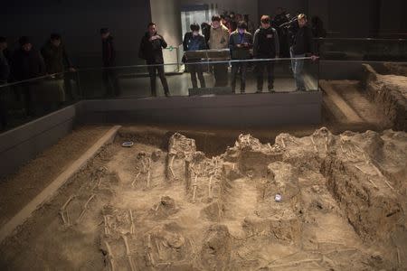 Journalists and visitors look at skeletons of victims of the 1937 Nanjing massacre at the Nanjing Massacre Museum during a media trip, in Nanjing, Jiangsu province, February 19, 2014. China pressed a propaganda campaign against Japan this week with a guided visit to the site of the 1937 Nanjing massacre, holding up proof to refute doubts by some in Japan about the extent of the atrocity or even that it happened at all. China's ties with Japan have long been poisoned by what China sees as Japan's failure to atone for its occupation of parts of China before and during World War Two. China is determined to sustain the memories. To match story CHINA-JAPAN/NANJING Picture taken February 19, 2014. REUTERS/Aly Song (CHINA - Tags: POLITICS CONFLICT CIVIL UNREST MEDIA SOCIETY)