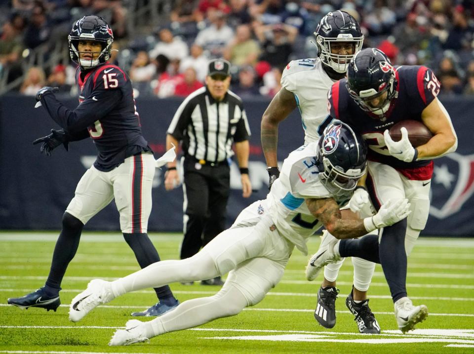 Houston Texans running back Rex Burkhead (28) tries to get away from Tennessee Titans safety Amani Hooker (37) during the third quarter at NRG Stadium Sunday, Jan. 9, 2022 in Houston, Texas.
