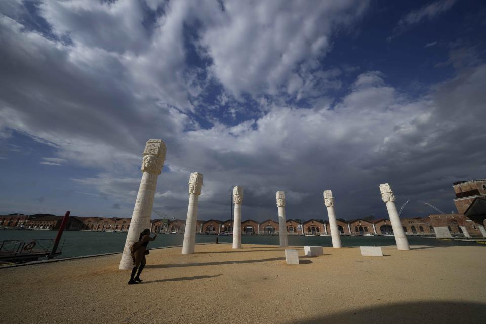 A visitor looks the installation "Keepers of the Krown," by artist Lauren Halsey, at the Arsenale, during the 60th Biennale of Arts exhibition in Venice, Italy, Tuesday, April 16, 2024. The Venice Biennale contemporary art exhibition opens Saturday for its six-month run through Nov. 26. (AP Photo/Luca Bruno)