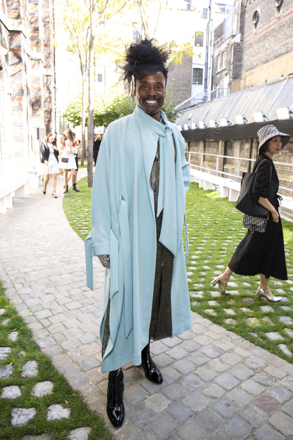 Billy donned a sky blue cape with a glittering silver jumpsuit underneath which he styled with a black fascinator at the Roland Mouret SS20 show [Photo: Getty Images]