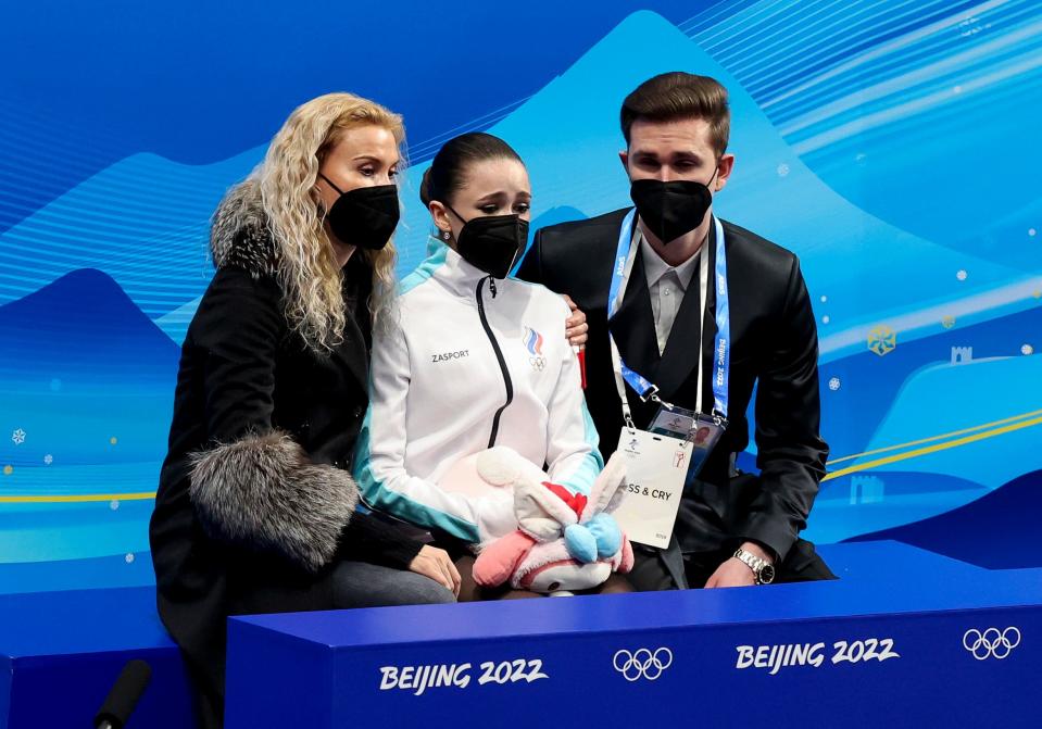 Eteri Tutberidze wraps her hand around Kamila Valieva's shoulder after the teen's performance.