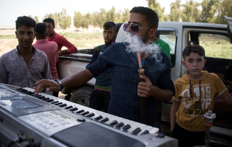 An Iraqi plays an electronic keyboard in a park in the Shallalat district, northeast of the city of Mosul, on May 12, 2017