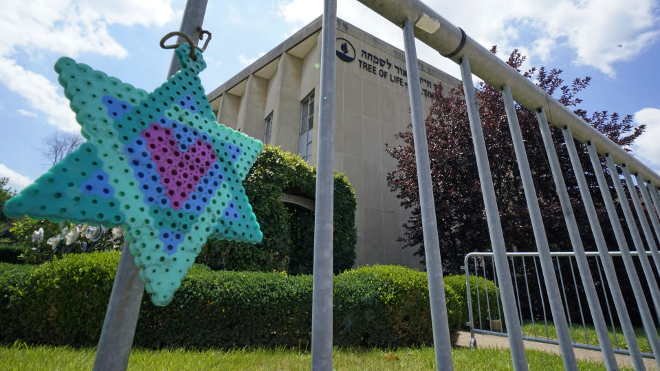 A Star of David hangs from a fence outside the dormant landmark Tree of Life synagogue in Pittsburgh's Squirrel Hill neighborhood on Thursday, July 13, 2023, the day a federal jury announced they had found Robert Bowers, who in 2018 killed 11 people at the synagogue, eligible for the death penalty. (AP Photo/Gene J. Puskar)