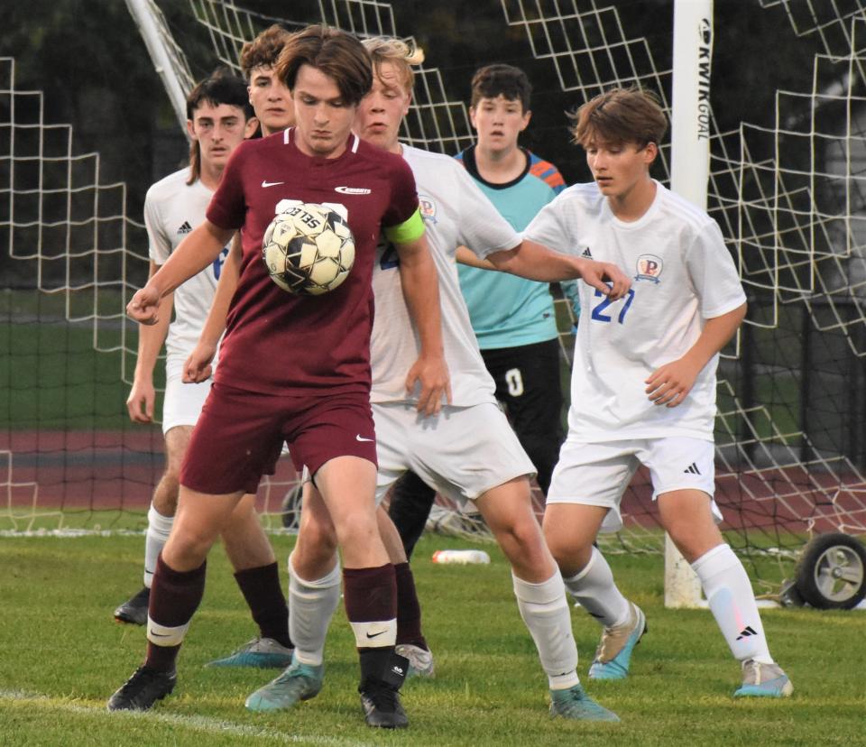 Frankfort-Schuyler's Collin MacDonald controls the ball in front of a crowd defending the Poland goal during the first half of Monday's match.