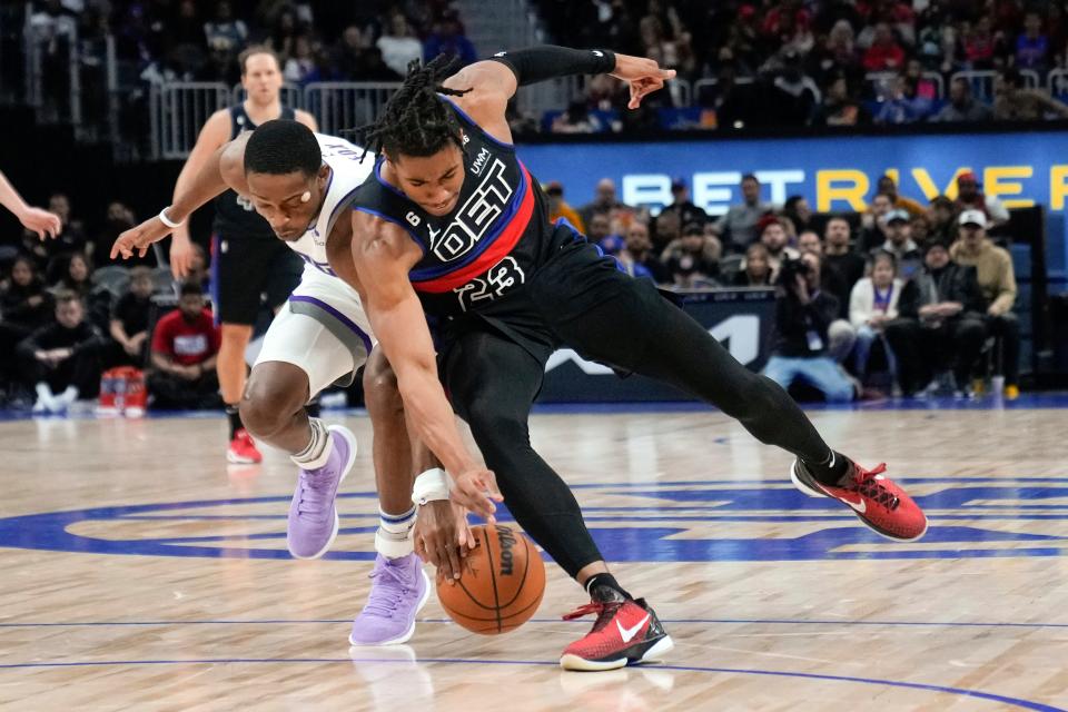 Kings guard De'Aaron Fox, left, and Pistons guard Jaden Ivey battle for a loose ball in the first half Dec. 16, 2022 in Detroit.