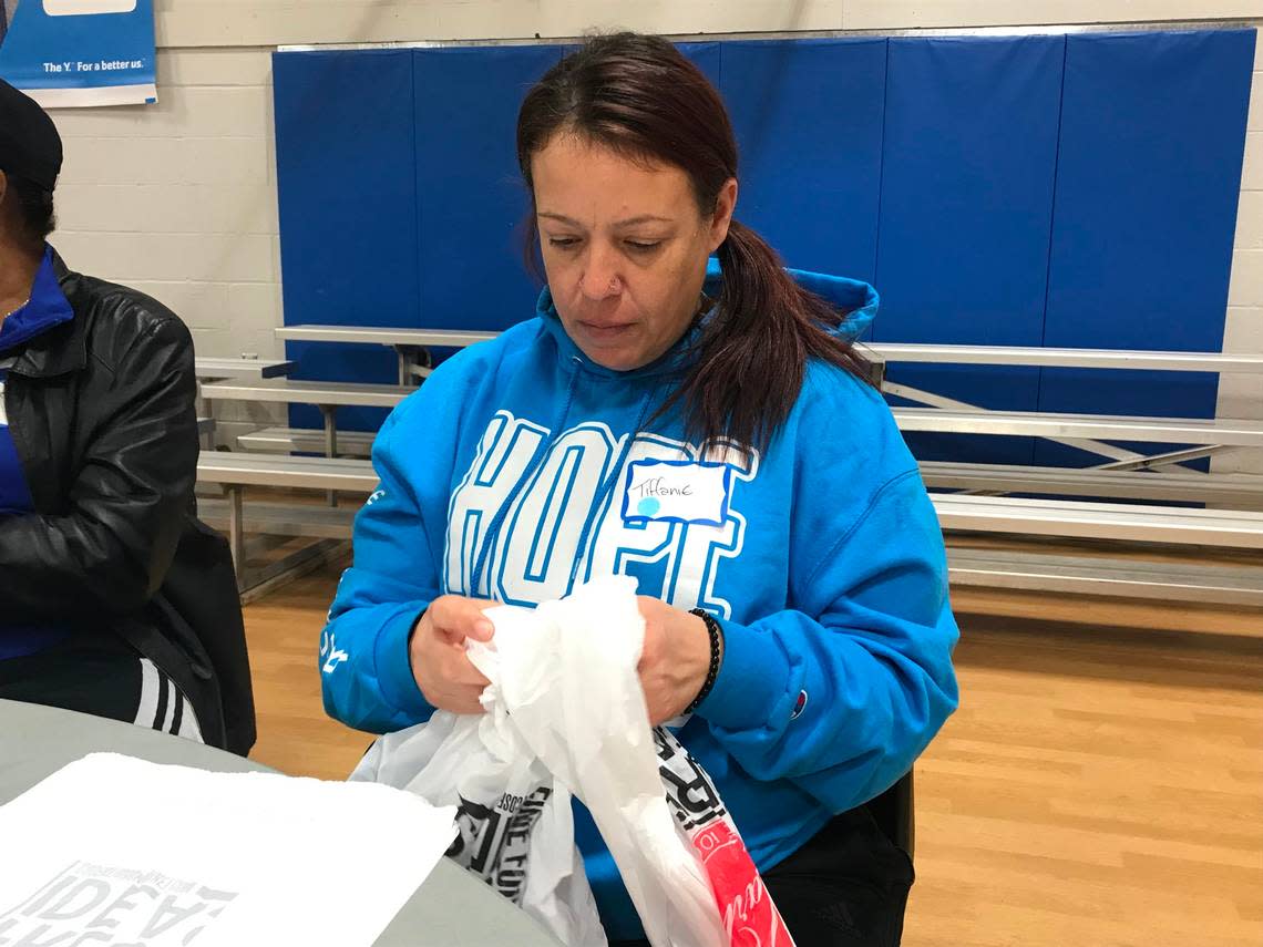 Volunteer Tiffanie J. strings together plastic bags to be woven into sleeping mats for the homeless at the Linwood YMCA.