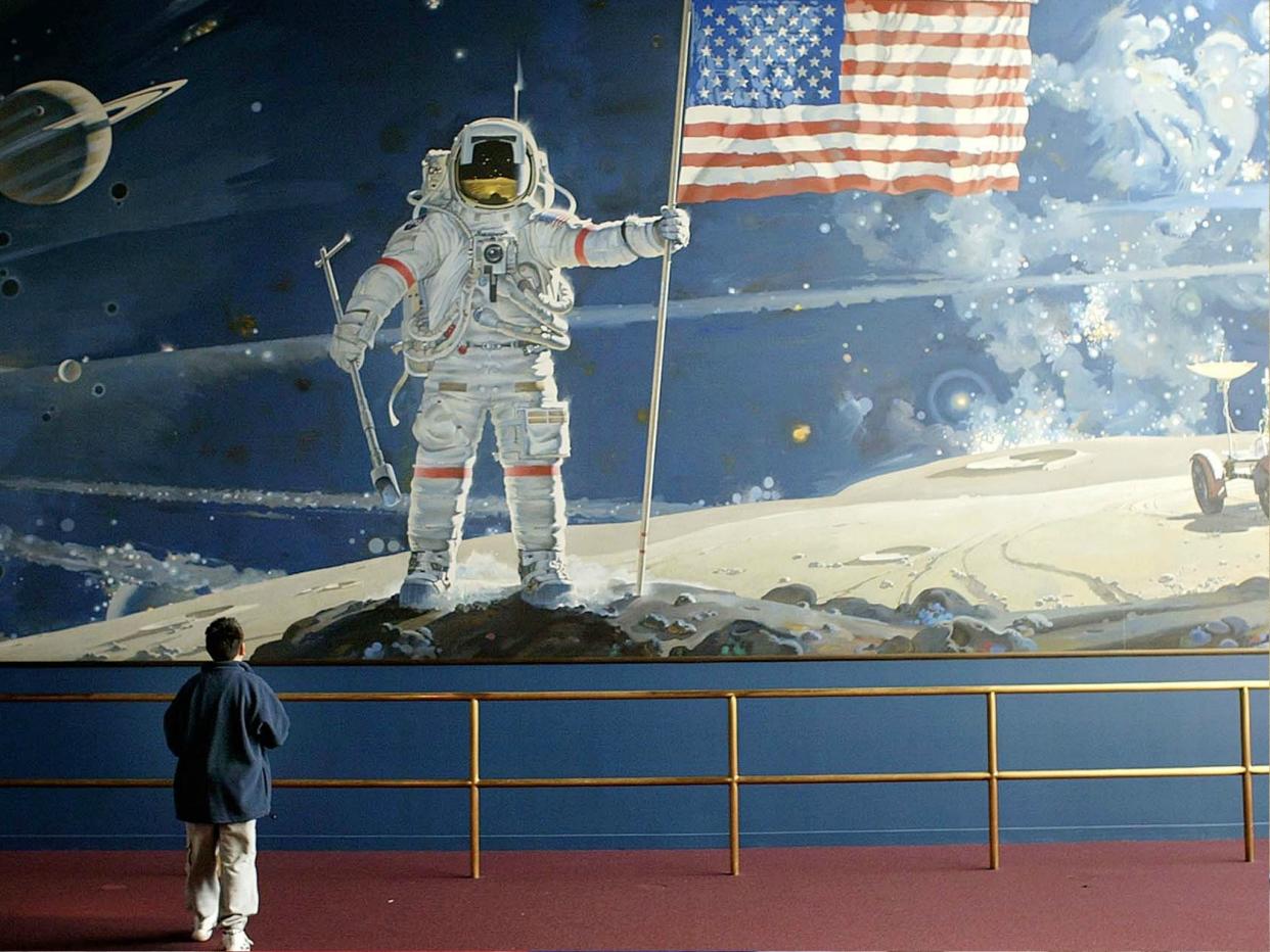 A boy looks at a wall-sized mural depicting an astronaut walking on the moon at the Smithsonian Air and Space Museum in Washington DC: Mark Wilson/Getty Images