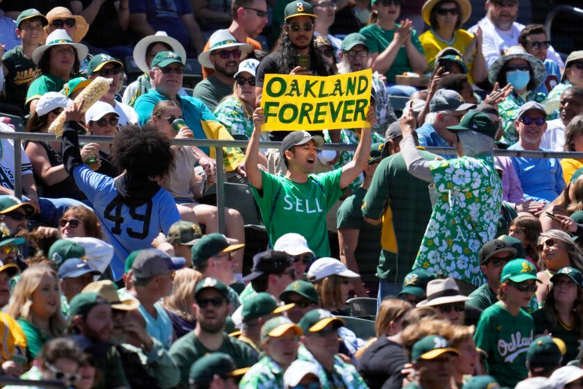 An Oakland Athletics fan holds up a sign protesting the team's planned move to Las Vegas on June 18, 2023.