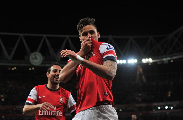 Arsenal's French striker Olivier Giroud kisses his shirt as he celebrates scoring a goal during the English Premier League football match between Arsenal and West Ham United at the Emirates Stadium in London on April 15, 2014