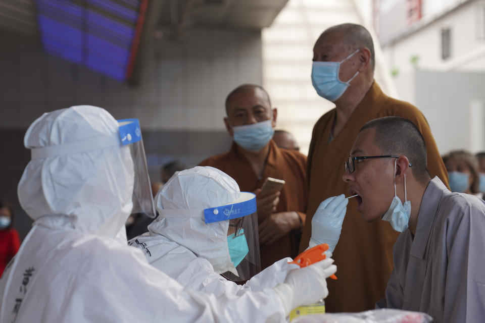 Monks get tested for the coronavirus in a district in Guangzhou in southern China's Guangdong province on Sunday, May 30, 2021. The southern Chinese city of Guangzhou shut down a neighborhood and ordered residents to stay home Saturday to be tested for the coronavirus following an upsurge in infections that has rattled authorities. (AP Photo)