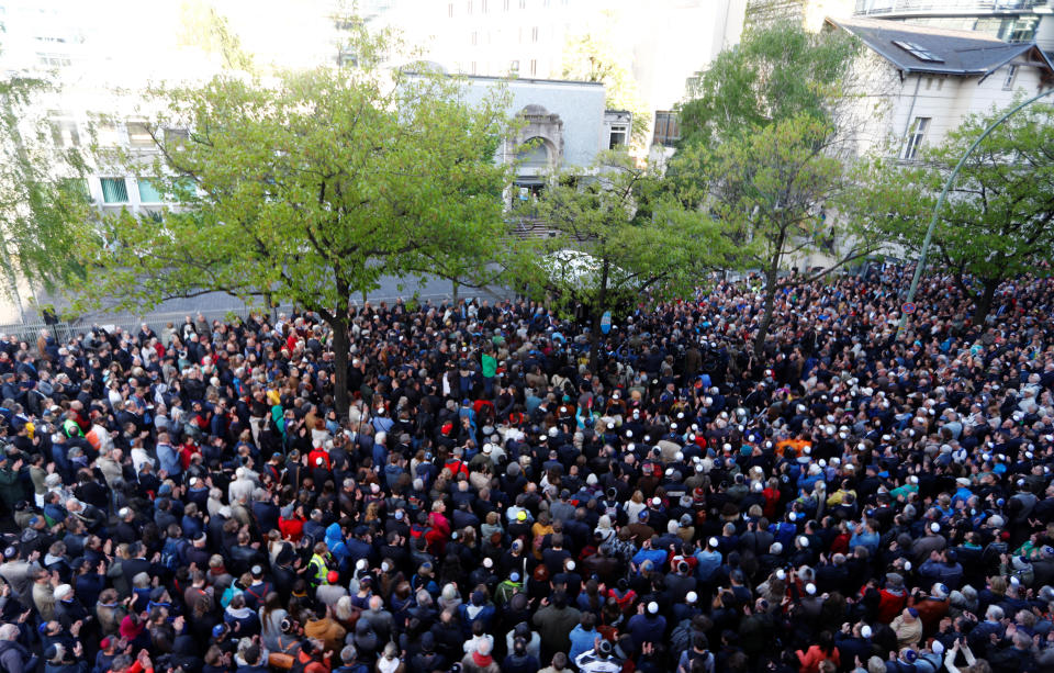 People wear kippas as they attend a demonstration in front of a Jewish synagogue in Berlin.