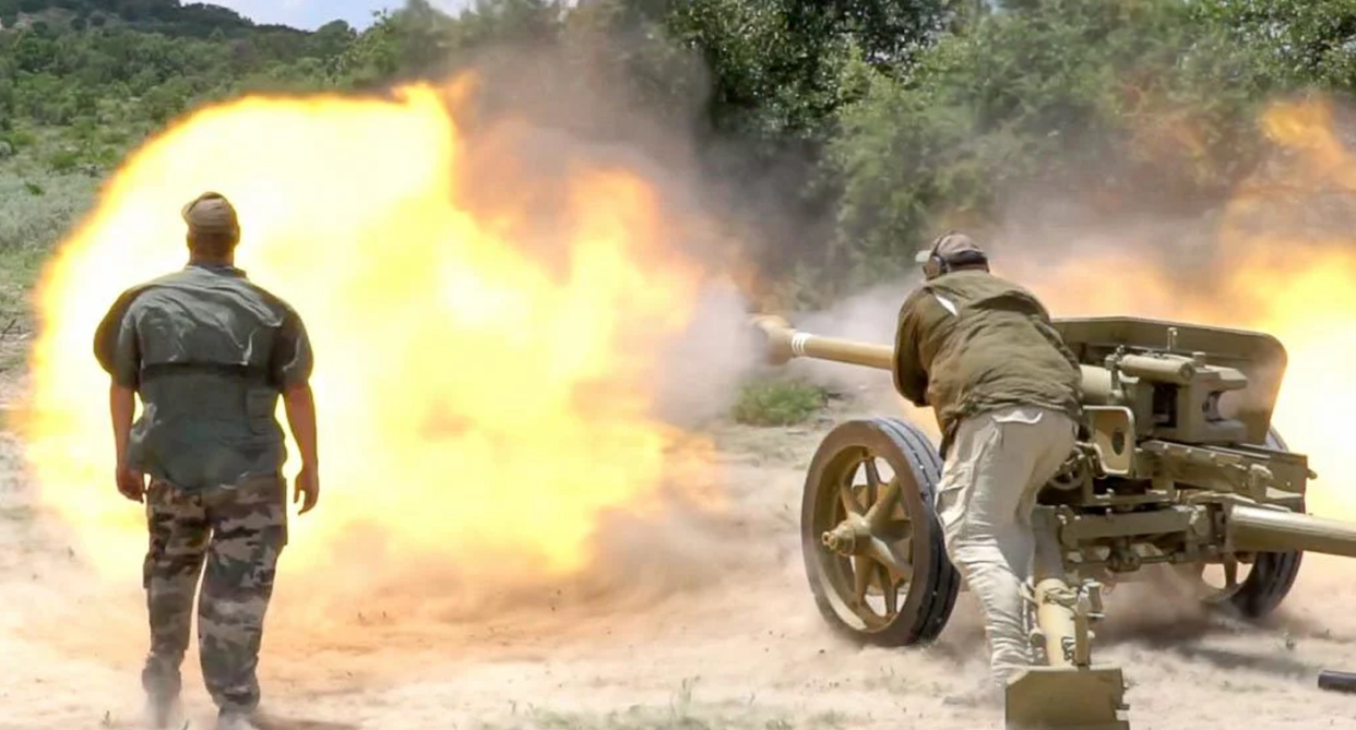 People shooting a machine gun at the ranch.