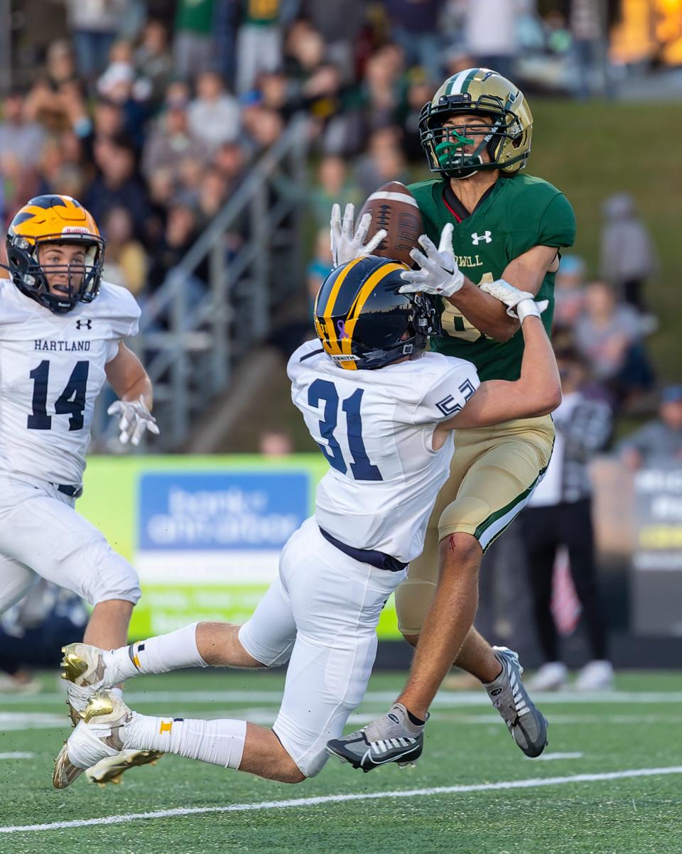 Howell's Brandon Hamilton hauls in a 35-yard pass while defended by Matthew Flynn to set up the first touchdown of the game in a 33-13 loss to Hartland on Friday, Sept. 30, 2022.