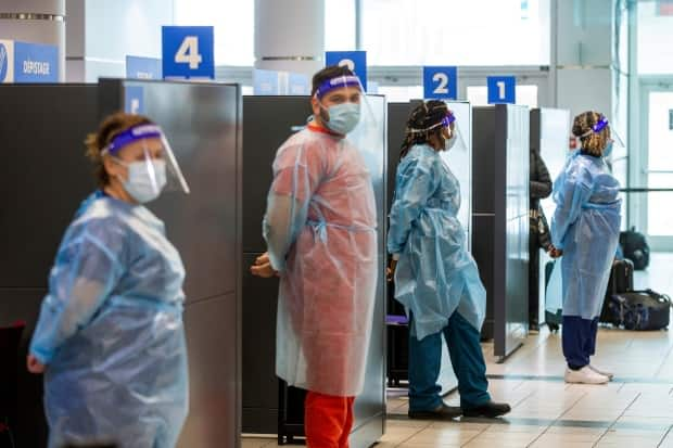 Health-care workers prepare to test passengers as they arrive at Toronto's Pearson airport in this Feb. 1, 2021 photo after mandatory COVID-19 testing took effect for international arrivals. Public Health Ontario said Friday it has detected 36 cases of the B1617 variant first identified in India. (Carlos Osorio/Reuters - image credit)