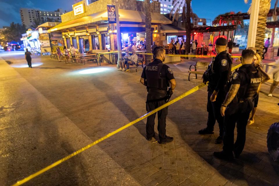 Police officers search the area where gunfire broke out along a beach boardwalk in Hollywood, Florida (EPA)