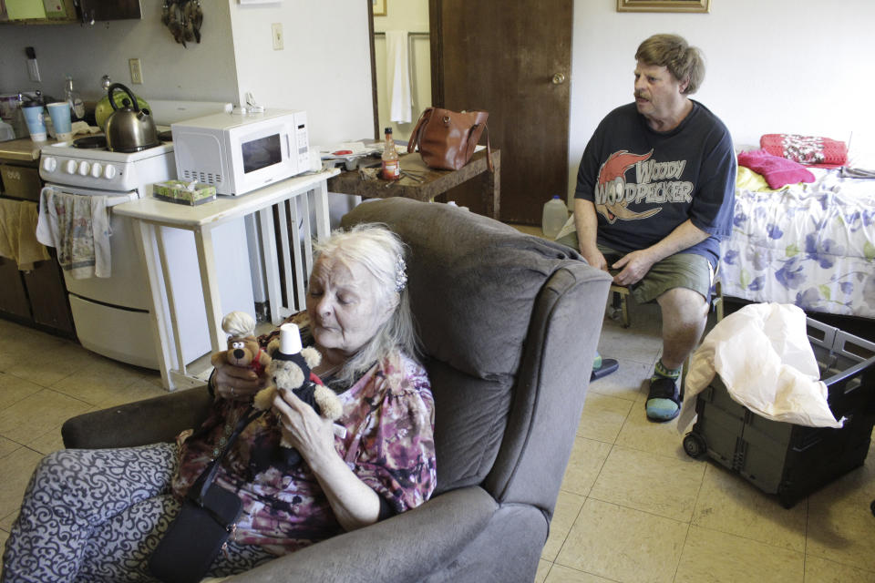 Karen Colby listens in on July 22, 2021 while her neighbor Joel Aslin tells how he called an ambulance for her when she got heat stroke as temperatures reached 107 F in her small fifth-floor studio apartment during a record-breaking heat wave in June, in Portland, Ore. The unprecedented heat, which reached 116 F in Portland, killed dozens of people in Oregon and hundreds across the region and was a wake-up call for the normally cool region as climate change accelerates. (AP Photo/Gillian Flaccus)