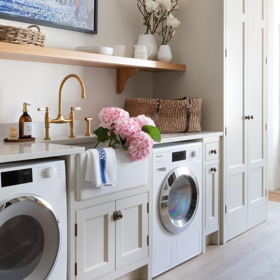 Neutral laundry room with washing machine, tumble dryer and Belfast sink