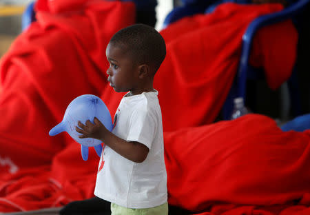 A migrant child, intercepted aboard a dinghy off the coast in the Strait of Gibraltar, plays as he rests in a makeshift emergency building after arriving on a rescue boat at the port of Barbate, southern Spain, July 27, 2018. REUTERS/Stringer