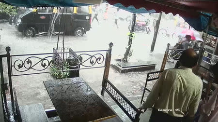 People look at a flooded street during heavy rains in Parel neighbourhood of Mumbai, India, August 29, 2017 in this still image obtained from a CCTV camera. TWITTER/@VIVEK_J_SINGH via REUTERS
