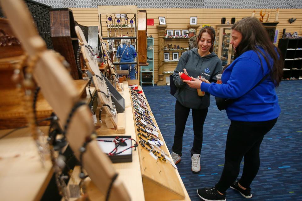 Samantha Conant and her mom Tammy Conant take a closer look at one of the many items available at Midnight, Moonlight and Magick at the Dartmouth Mall.